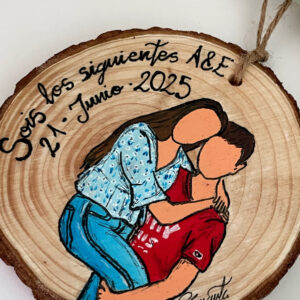 Detalle personalizado en madera con pareja abrazada y texto de boda 2025.