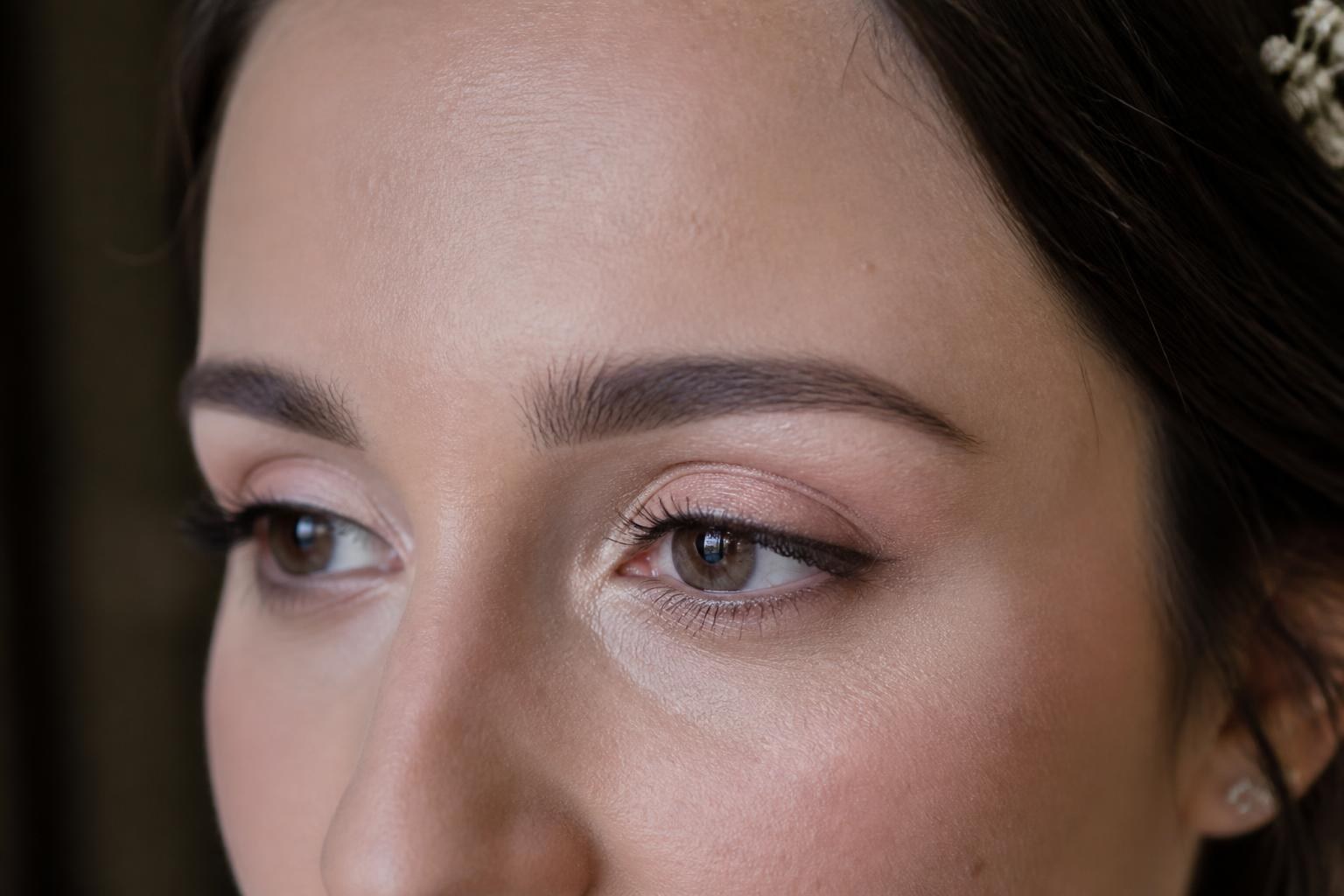 Primer plano realista de una novia con maquillaje de ojos de ángel en tonos claros y pestañas ligeras