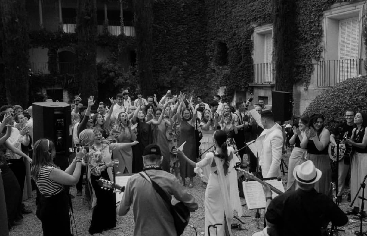 1000079100 Banda tocando en un patio mientras el público aplaude y disfruta del concierto.