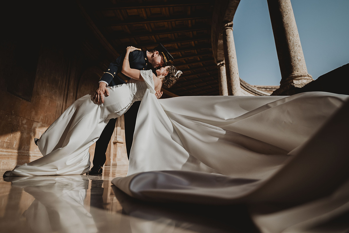 ernst-prieto-10 Novios en pose de baile bajo un techo de madera con columnas y vestido de novia largo extendido.