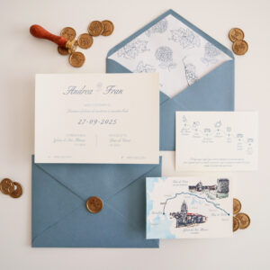 Invitación de boda con sobre azul, sello de lacre y monedas de cobre alrededor sobre fondo claro.