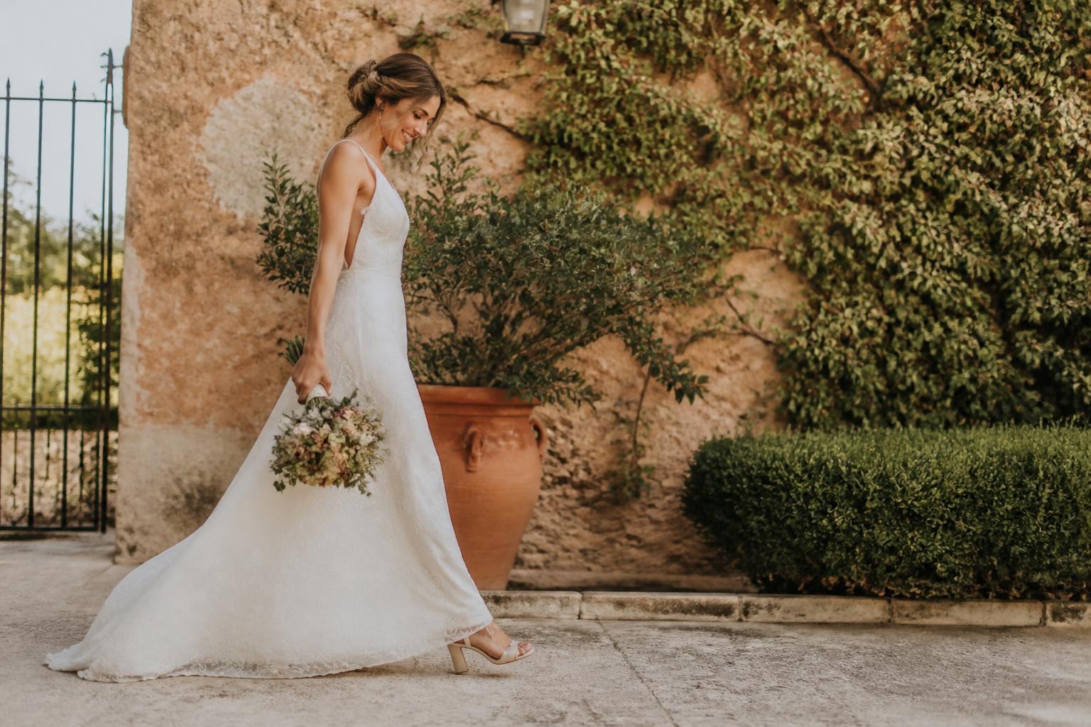 Novia caminando al aire libre con un ramo-bolso floral equilibrado
